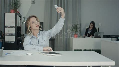 Beautiful Young Office Worker In Headset Taking Selfies Using Phone