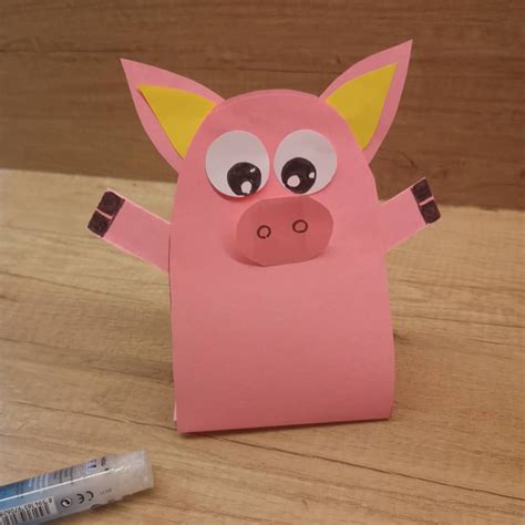 A Pink Paper Pig Standing On Its Hind Legs With Eyes Wide Open And