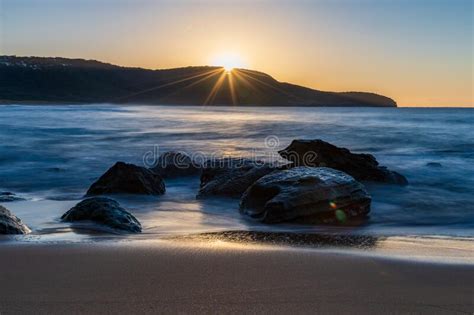 Sunrise At The Seaside With Clear Skies And Sunburst Stock Image