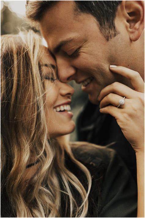 A Man And Woman Smile As They Hold Each Other Close To Their Foreheads
