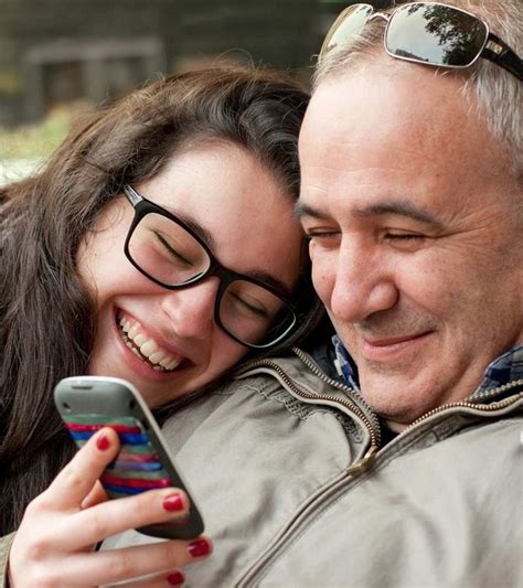 A Man And Woman Taking A Selfie On Their Cell Phone While They Both