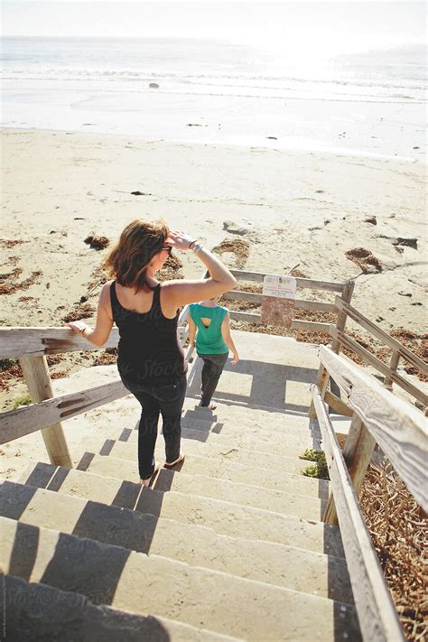 woman walks down stairs to beach by stocksy contributor jayme burrows stocksy