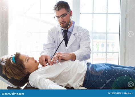 Girl Being Examined With Stethoscope By Pediatrician In The Office
