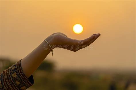 Silhouette Of Young Girl Holding The Sun In Hand During Sunset Closeup