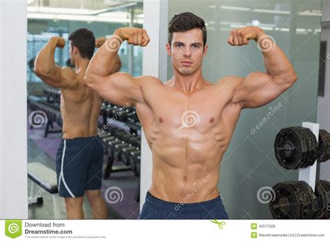 Shirtless Muscular Man Flexing Muscles In Gym Stock Image