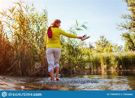 Middle-aged Woman Walking On River Bank On Spring Day. Senior Lady Having Fun In The Forest ...