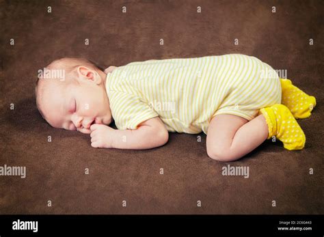 Beautiful Newborn Baby Boy Sleeping Peacefully On The Soft Brown