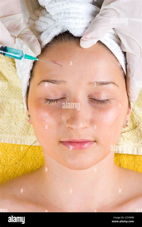 Young Woman Getting A Botox Injection To Forehead And Lying With Eyes