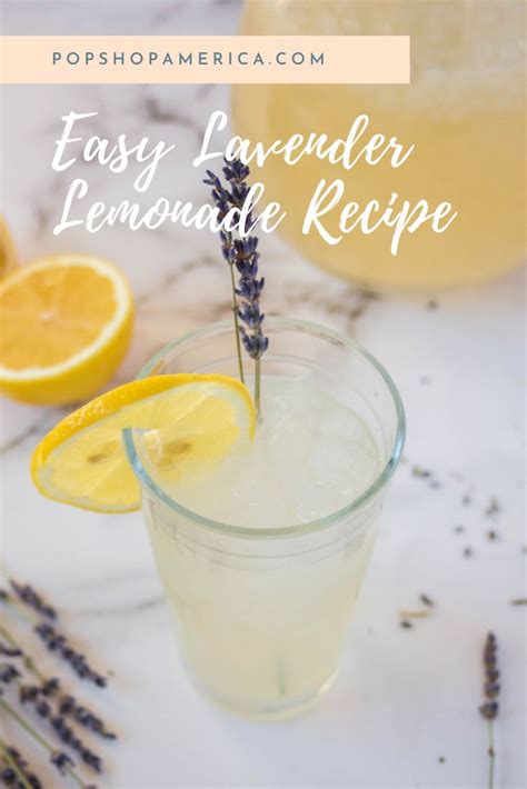 A Lemonade Drink In A Glass With Lavender Sprigs And Lemons On The Side