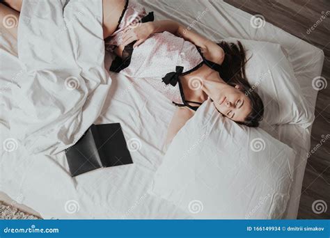 Girl In Pajamas Lying On The Bed With A Book Before Bed Stock Photo