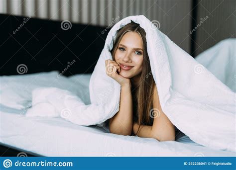 Smiling Woman Under A Duvet In Bedroom Stock Image Image Of Pillow