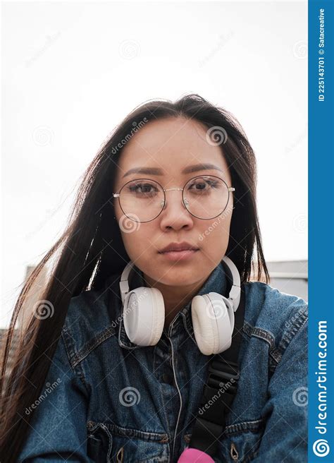 portrait of an asian girl wearing glasses and headphones stock image image of strong