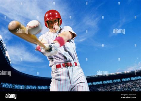 A Professional Baseball Player Swinging And Hitting A Baseball Stock
