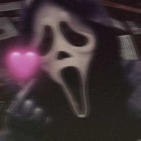 A Person Wearing A Ghost Mask Holding A Pink Heart In Their Hand And