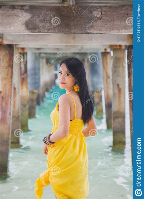 Portrait Beautiful Asian Woman In A Yellow Dress Standing Under The