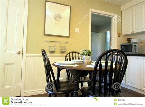 An exposed brick wall can add character to your black and white dining. Kitchen With White Cabinets And Round Table And Chairs ...