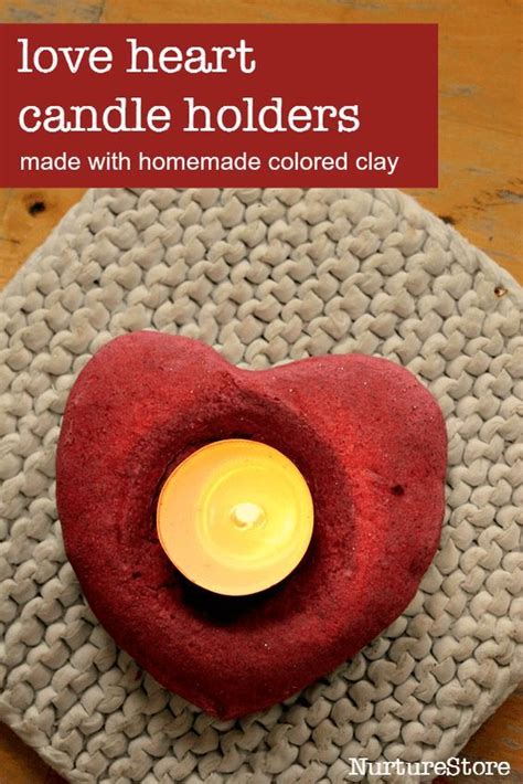 A Red Heart Shaped Candle Holder On Top Of A Plate With The Words Love