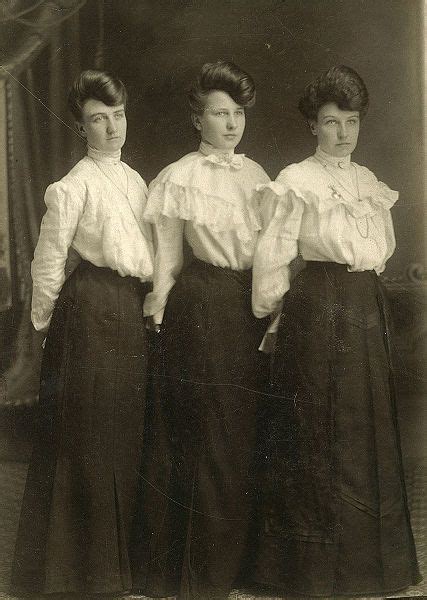 Three Women Standing Next To Each Other In Long Skirts