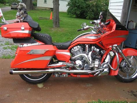 A Red Motorcycle Parked In Front Of A House