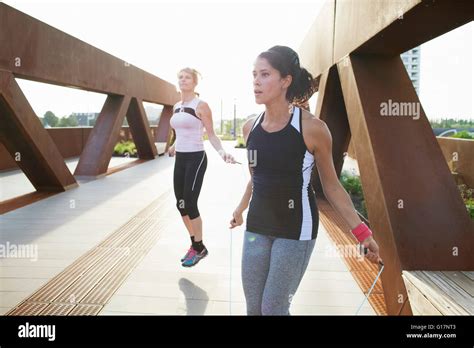 Two Women Training With Skipping Ropes On Urban Footbridge Stock Photo