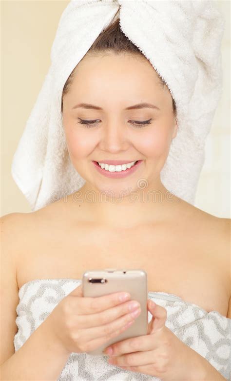 Beautiful Smiling Young Woman with a White Towel Covering Her Head is