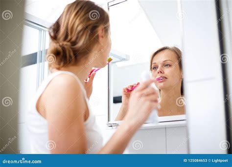 Pretty Female Brushing Her Teeth In Front Of Mirror Stock Image Image