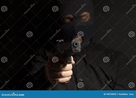 Criminal Bandit Man Wearing In Balaclava Holds A Gun In His Hand Stock