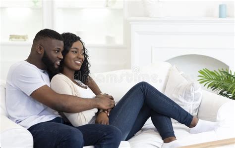 Happy Black Couple Hugging While Sitting On Couch At Home Stock Image Image Of Looking Female