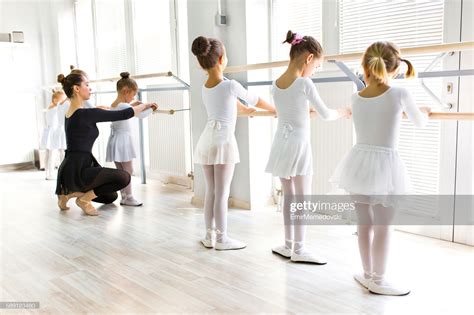 Ballet Teacher Helping Girls With Postures During Ballet Class High Res