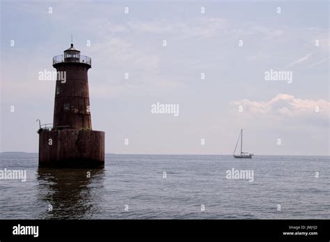 Lighthouse With Sailboat In The Background Stock Photo Alamy