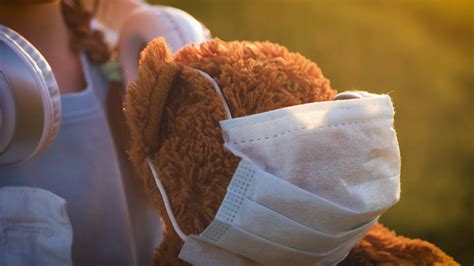 Sad Little Girl And Teddy Bear With Surgical Mask At