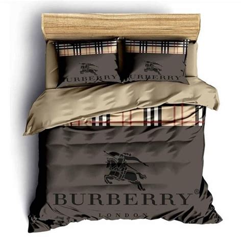 A Bed With Burbery On It And Two Pillows