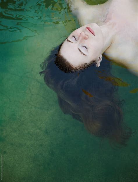 Woman Floating In Water At Hot Springs Spa By Stocksy Contributor