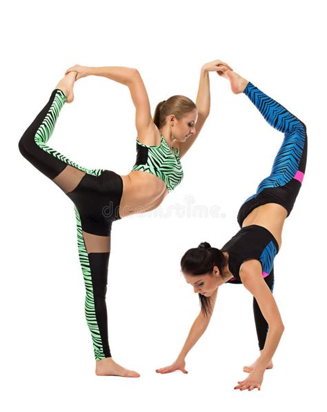 Flexible Girls Doing Difficult Acrobatic Tricks With A Pole Stock Image
