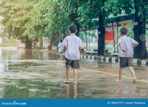 Boy Students Leave The Classroom To Walk On The Street After Heavy Rain