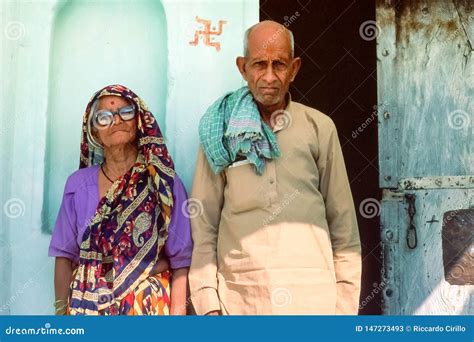 an elderly hindu couple standing outside their rural home rajasthan northern india editorial