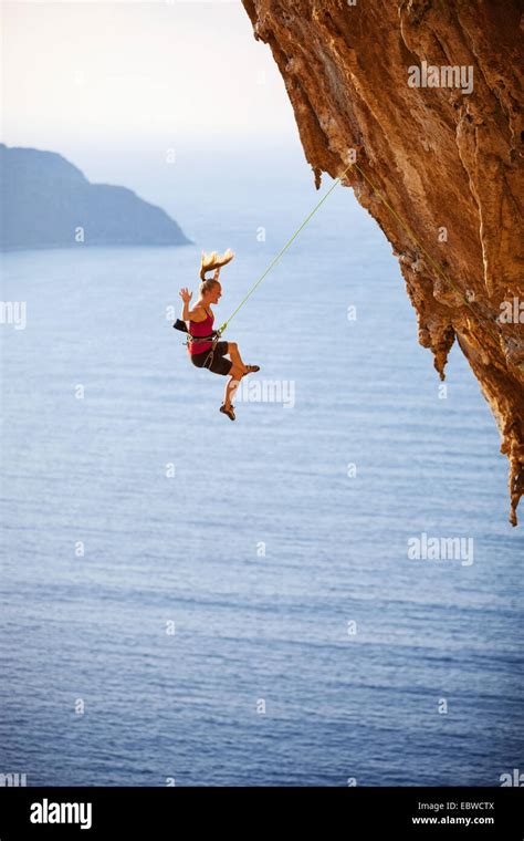 Female Rock Climber Falling Of A Cliff While Lead Climbing Stock Photo