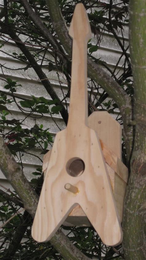 A Wooden Bird House Hanging From A Tree