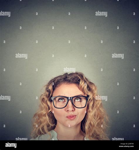 Young Skeptical Woman Looking Up Isolated On Gray Wall Background With