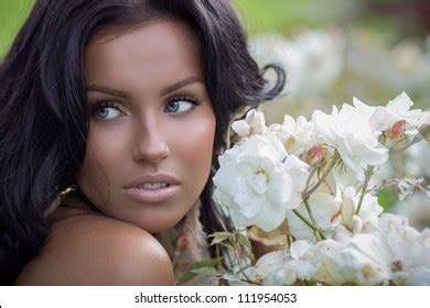 Beautiful Tanned Brunette Posing Near White Stock Photo