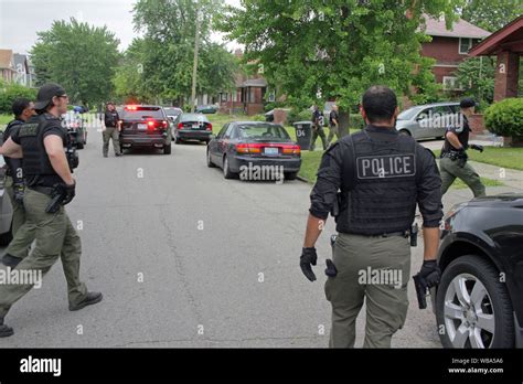 detroit police department special ops officers approach a house as they search for a wanted