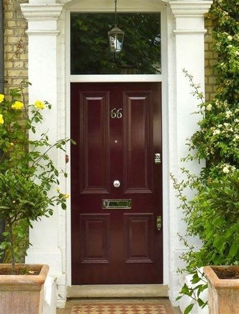 A Red Front Door With Two Planters On Either Side