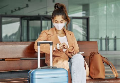 Médico con experiencia en salud ocupacional empresa ubicada por el aeropuerto de qro. Mujer con máscara médica mirando su reloj en el aeropuerto ...