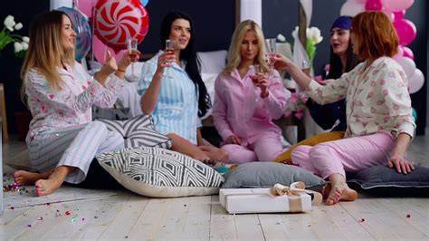 A Group Of Dancing Girls At A Pajama Party With Glasses Of Champagne Laugh And Smile The