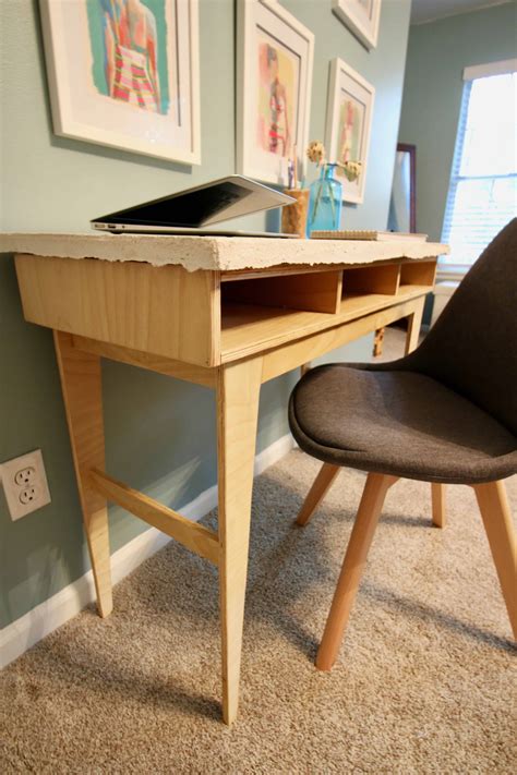 I glued the pieces that i cut off of the table top corners to each other to make 2 triangular braces that i used sandpaper to smooth down the edges of the plywood and to round over the edges just a little bit. DIY Plywood Concrete Desk