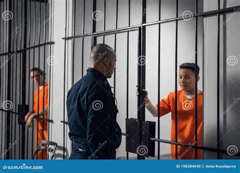 The Prison Warden Puts The Prisoner Behind Bars After The Court Verdict And Locks The Cell