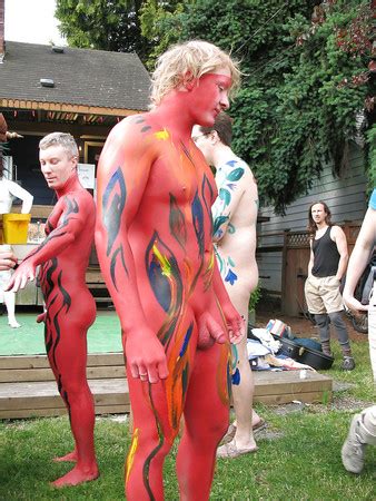 Side View Of Naked Man With Body Paint Kneeling Over Black Background