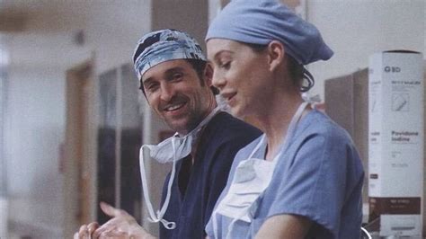 A Man And Woman In Scrubs Standing Next To Each Other