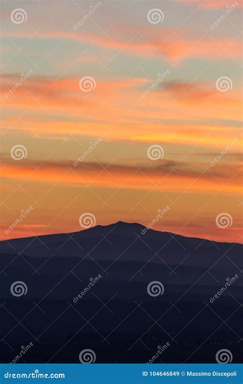 A Silhouette Of A Mountain Peak At Sunset Under A Big Sky With Stock