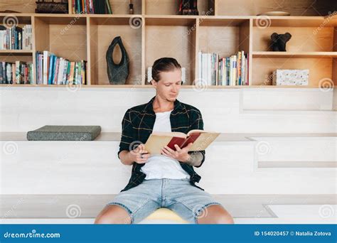 Serious Male Student Reading A Book In A Library Stock Image Image Of